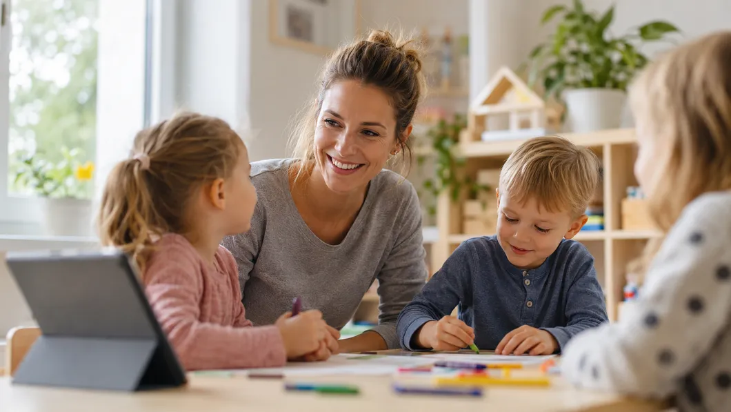 Éducatrice en école maternelle montrant son certificat de santé numérique sur son smartphone